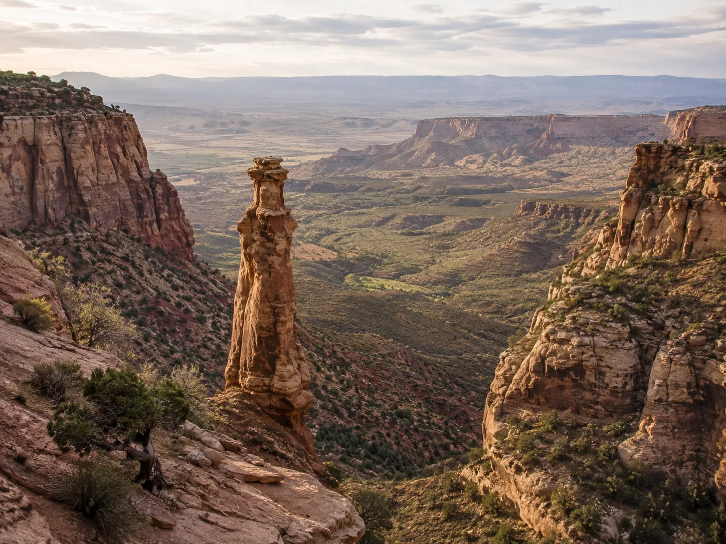 Colorado National Monument canyon overlook with towering red-rock formations and Independence Monument spire